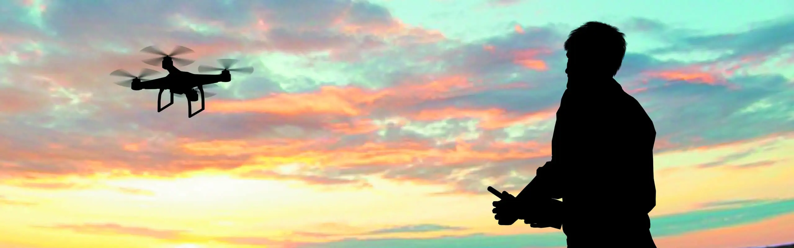 man operating of flying drone quadrocopter at sunset drone