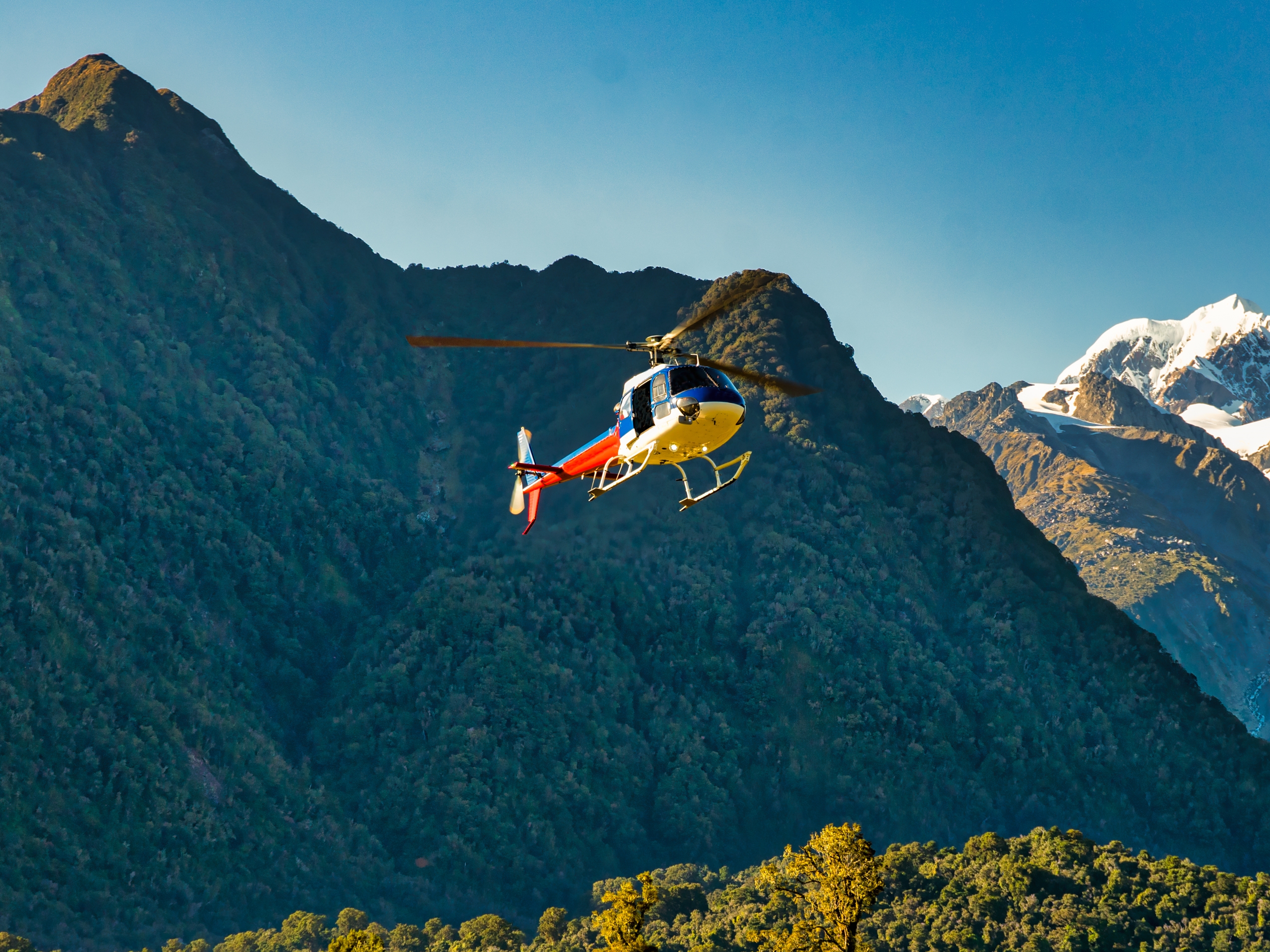 Helicopter flying off to the Glacier in the mountains